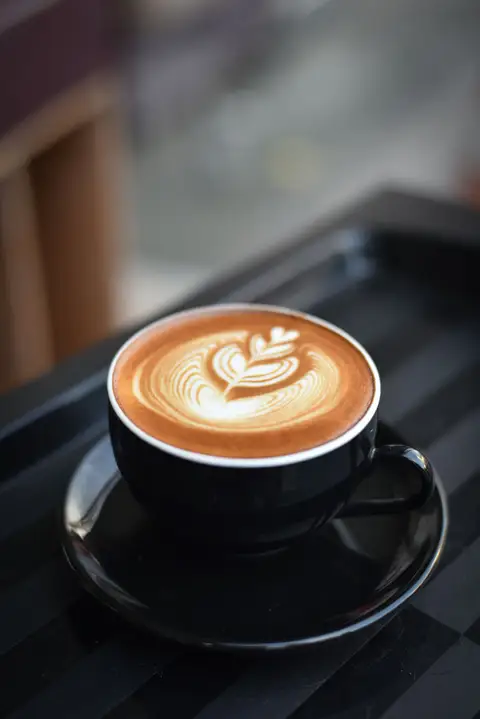 Barista at work in a warmly lit specialty coffee shop